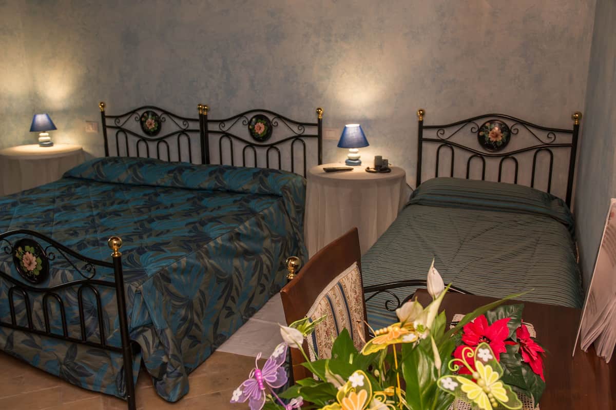 Une chambre à coucher avec deux lits, chacun doté d’une tête de lit et de tables de chevet avec des lampes.