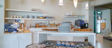 A buffet area with various food items and a self-serve hot pancake station.