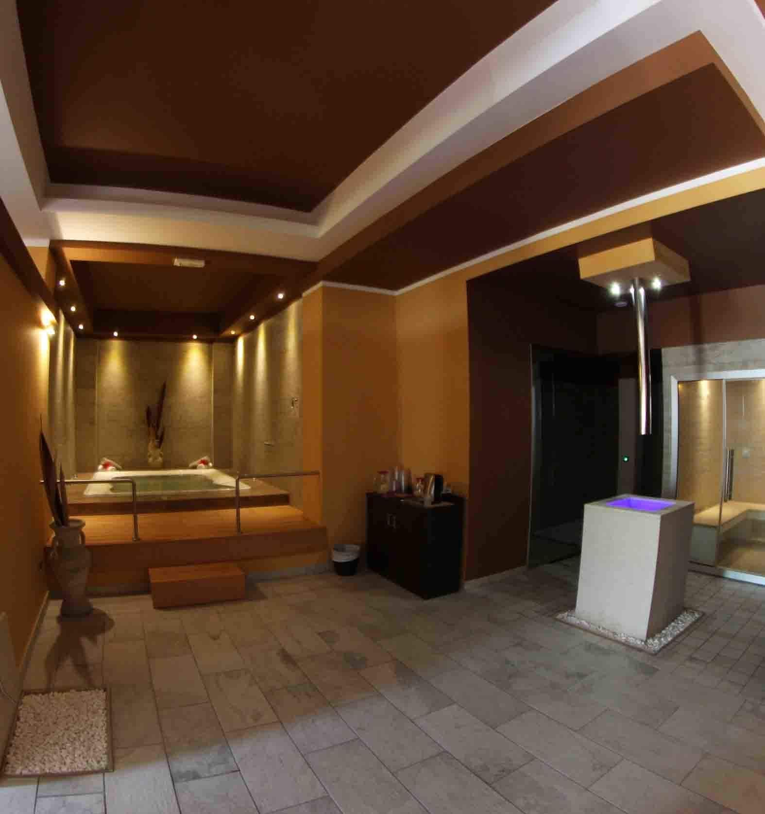 A spacious bathroom with a large bathtub, a shower area, and a vanity with a mirror.