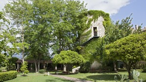 A garden with a stone building, trees, and a pathway. - Il Granaio dei Casabella (Capaccio-Paestum)