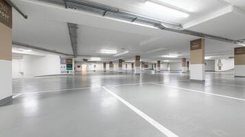 A spacious parking garage with clear directional signage, multiple parking levels, and a well-lit environment.