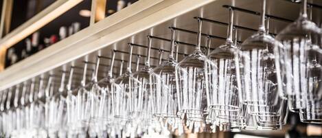 Una hilera de copas de vino colgando en un bar.