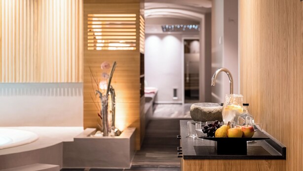 A modern bathroom with a wooden vanity, a sink, and a mirror. - Hotel Post (Brunico)
