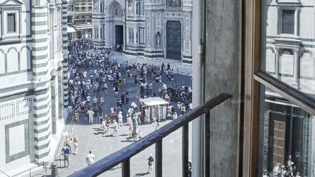 A crowded square with a historic building featuring intricate architectural details. - Soggiorno Battistero (Florence)