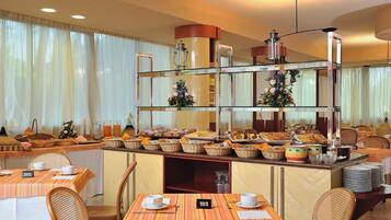 A breakfast buffet with various food items, wicker chairs, and a number 102 table.