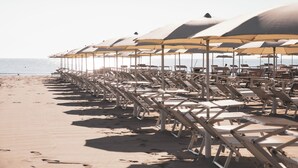 A beach with rows of sun loungers and umbrellas. - Hotel Baya Strand (Cervia)