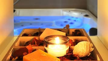 Une boîte décorée avec une bougie, un savon et des fleurs séchées.