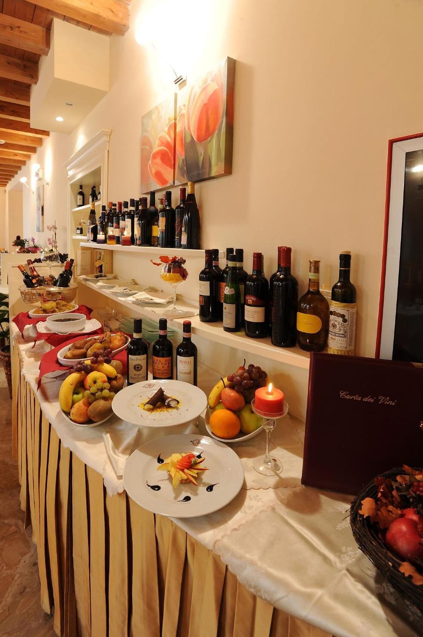 A buffet table with various food items and wine bottles.