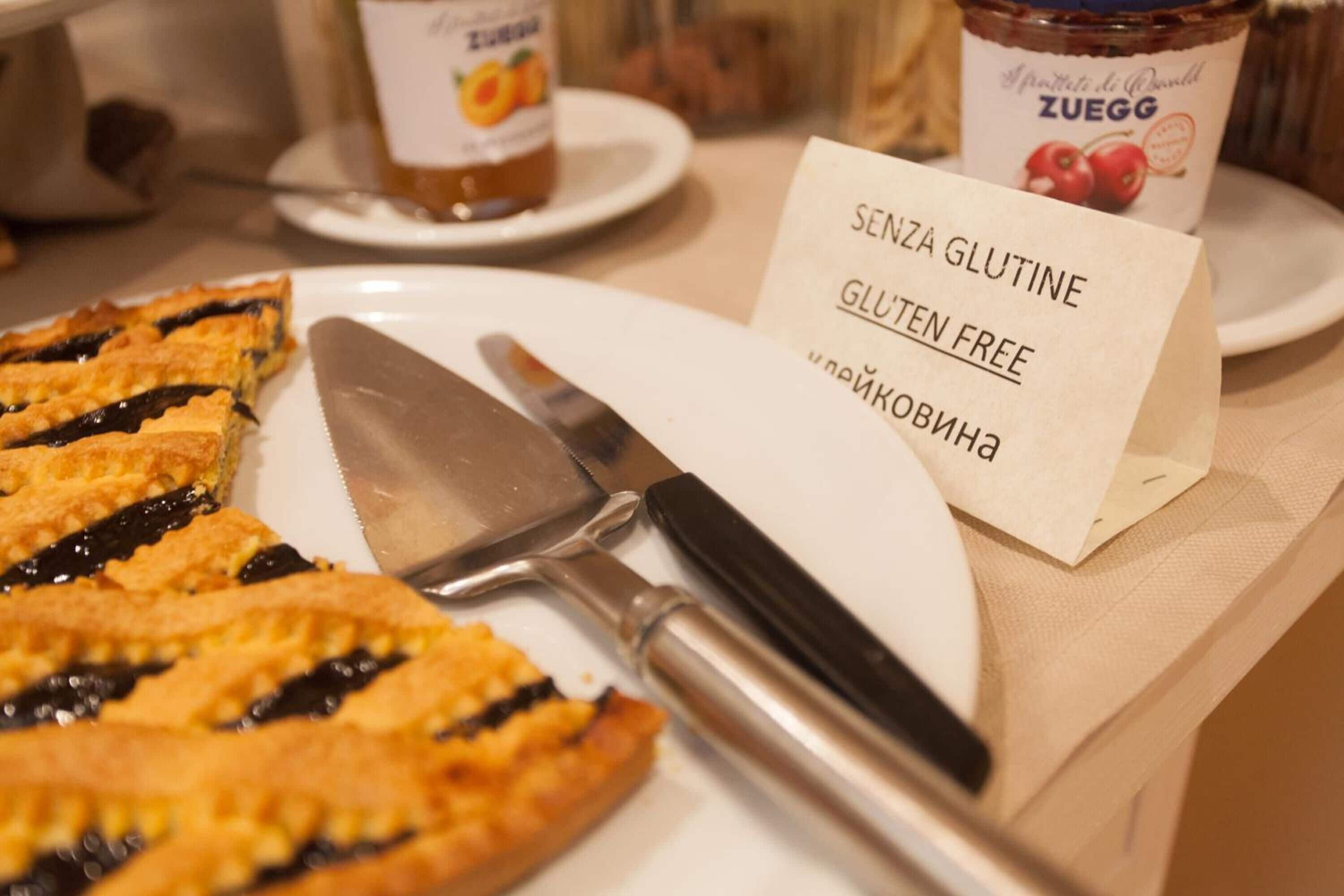 A gluten-free pie on a plate with a knife and a sign indicating it's gluten-free.