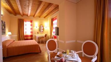 Une chambre d’hôtel avec deux lits, une table à manger où le petit-déjeuner est servi, une télévision et un bureau.