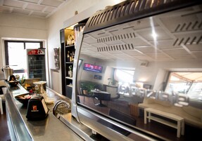 Una cocina moderna con una cafetera espresso de acero inoxidable, un molinillo de café y una pantalla digital.