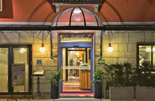 A restaurant entrance with a sign reading "RISTORANTE" and "BENVENUTI - VE'LO COME" welcoming guests.