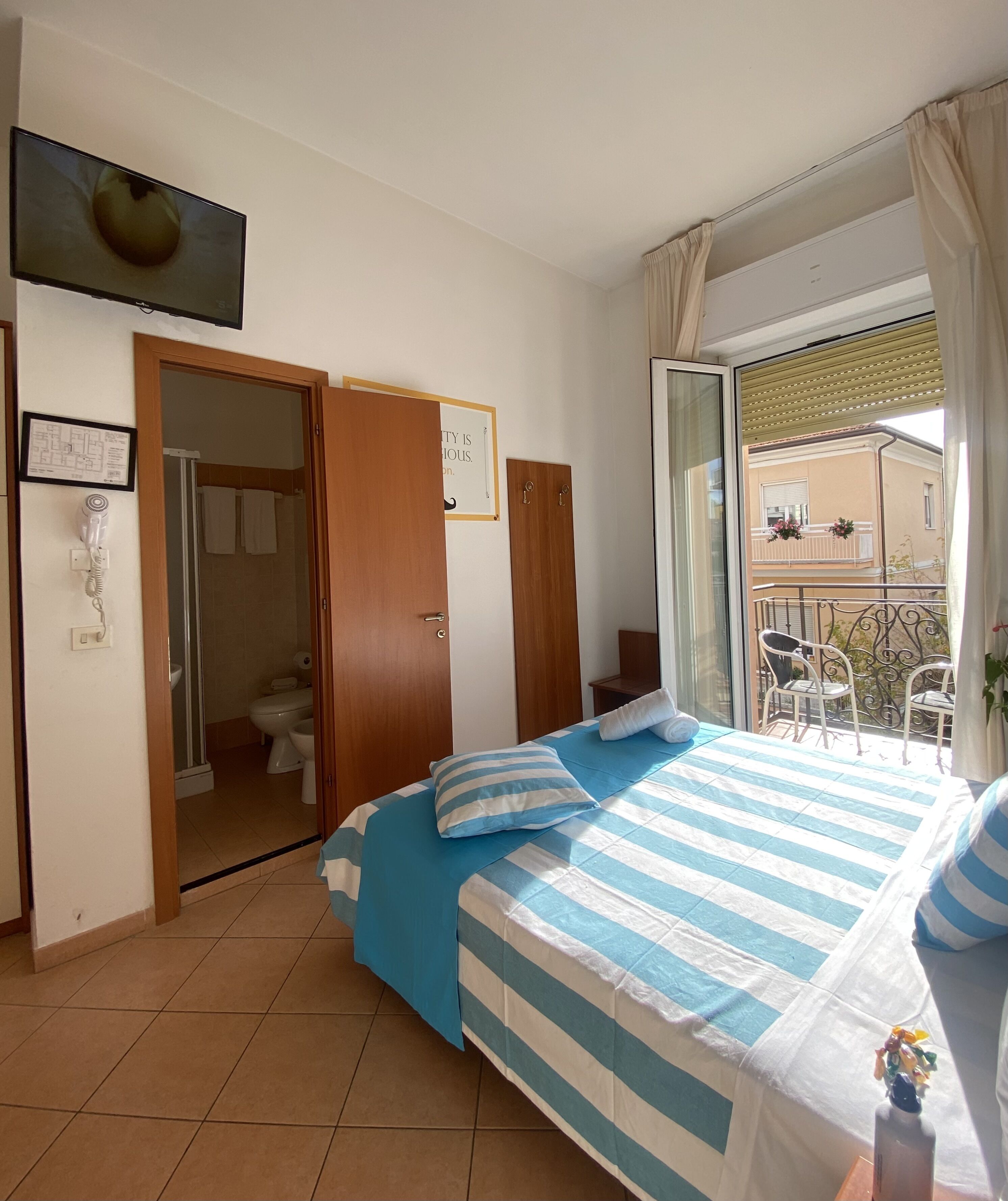 Una camera da letto con un letto, bagno e balcone.