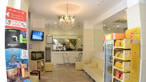 A lobby with a chandelier, seating area, and a snack vending machine. - Hotel Villa Caterina (Rimini)