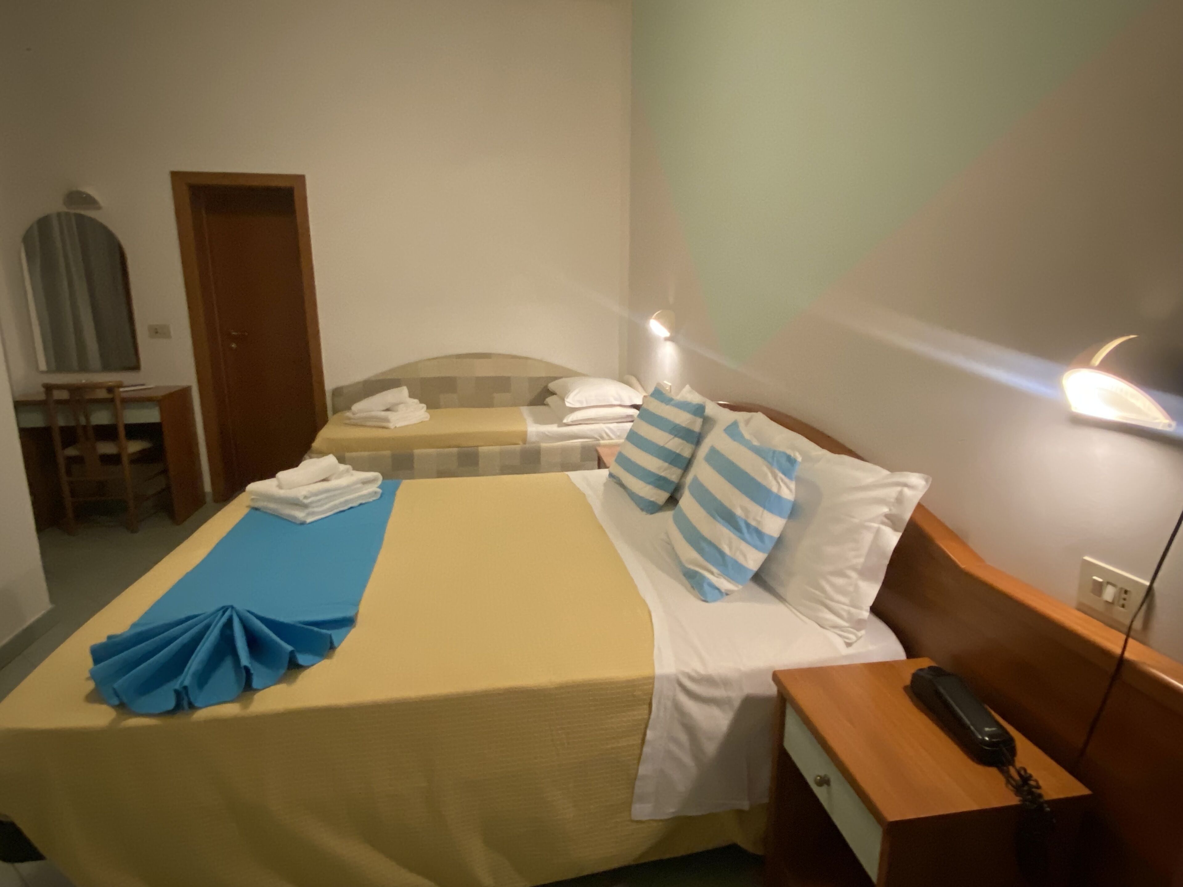 Una habitación de hotel con cama, escritorio y silla.