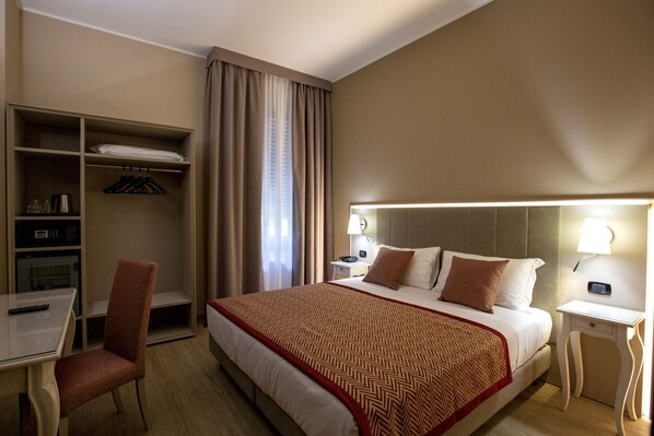 A hotel room with a bed, a desk, a chair, a wardrobe, and a nightstand. - Hotel Villa Malpensa (Vizzola Ticino)