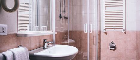 A modern bathroom with a glass shower enclosure, a sink, and a toilet.