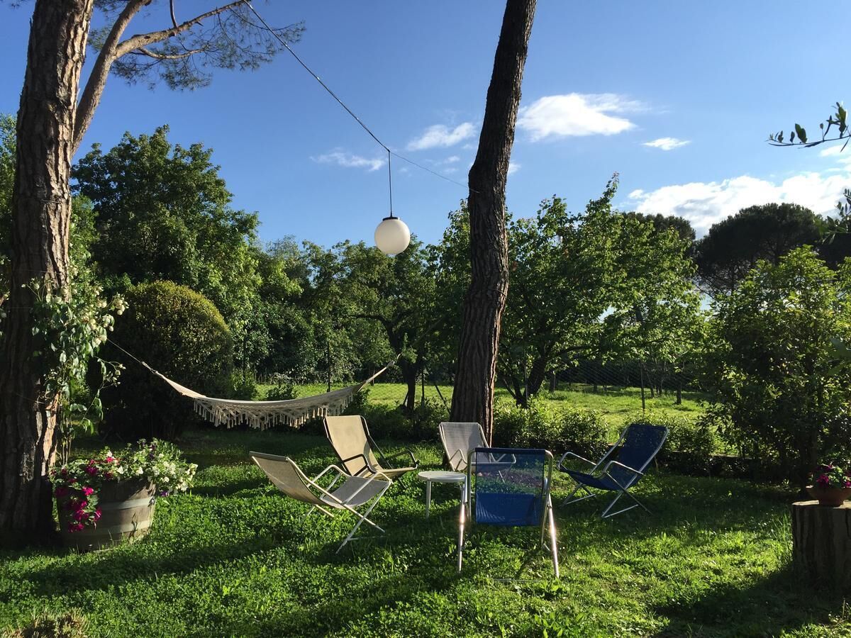 Un espace extérieur verdoyant avec plusieurs chaises et un hamac.