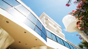 Un edificio moderno con fachada de vidrio, balcones y exterior blanco.