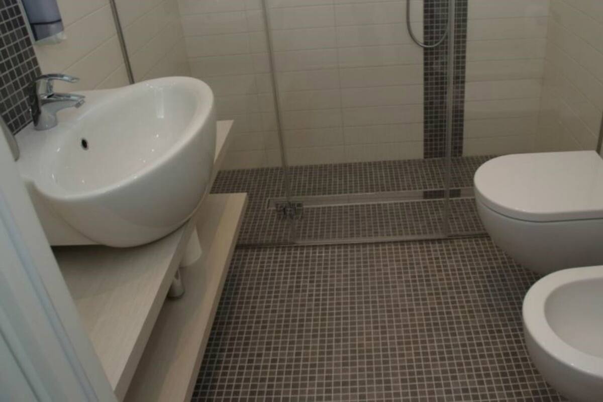 A small bathroom with a sink, toilet, and bidet.