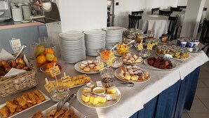 Una mesa de buffet con diversos alimentos y utensilios.