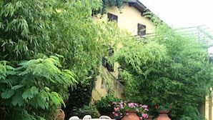 A rustic building with a stone wall and potted plants.
