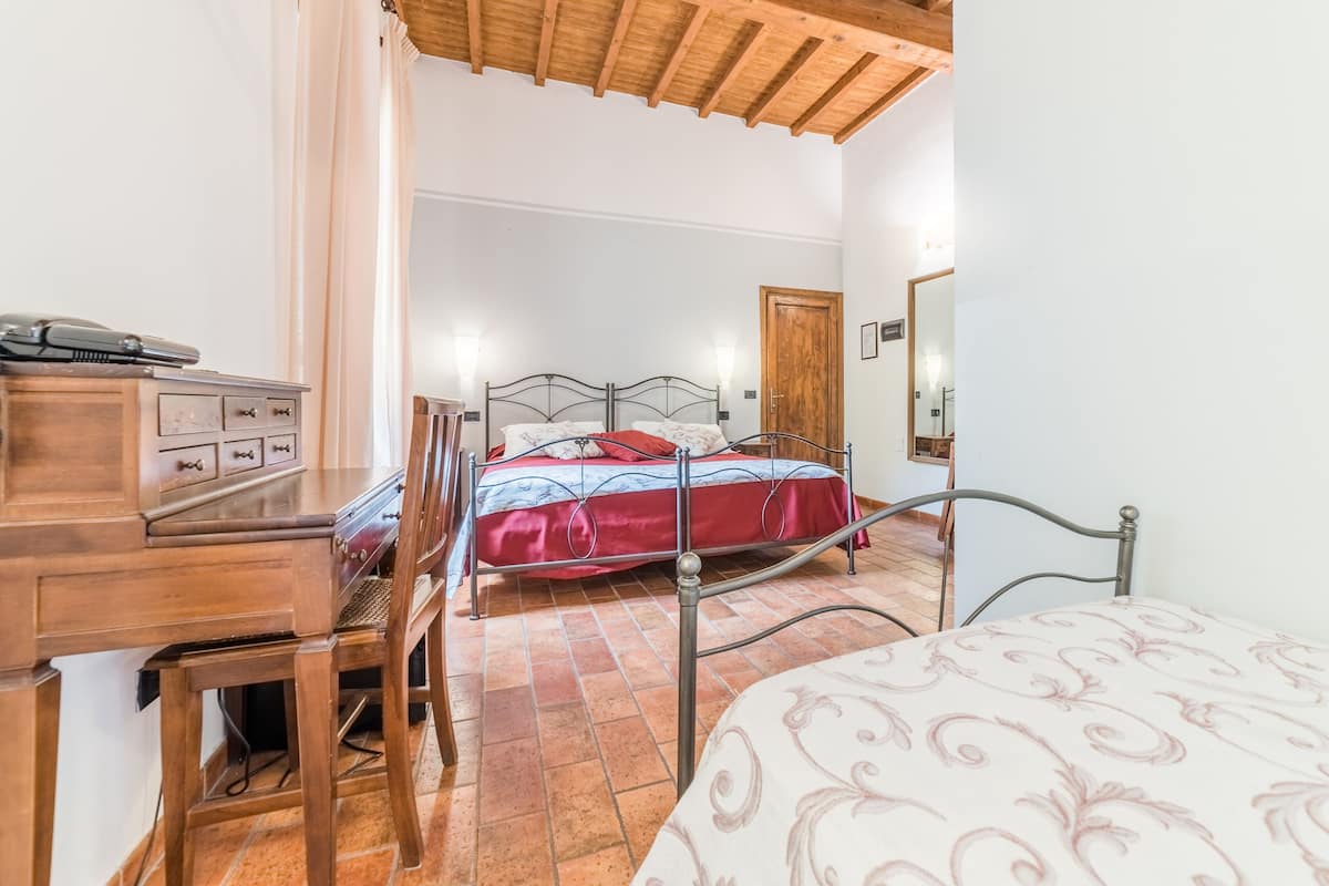 A bedroom with a bed, a desk, and a chair.