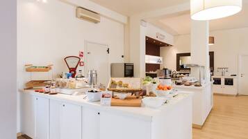 Une cuisine spacieuse dotée d’un îlot central, de meubles blancs et de divers appareils de cuisine.