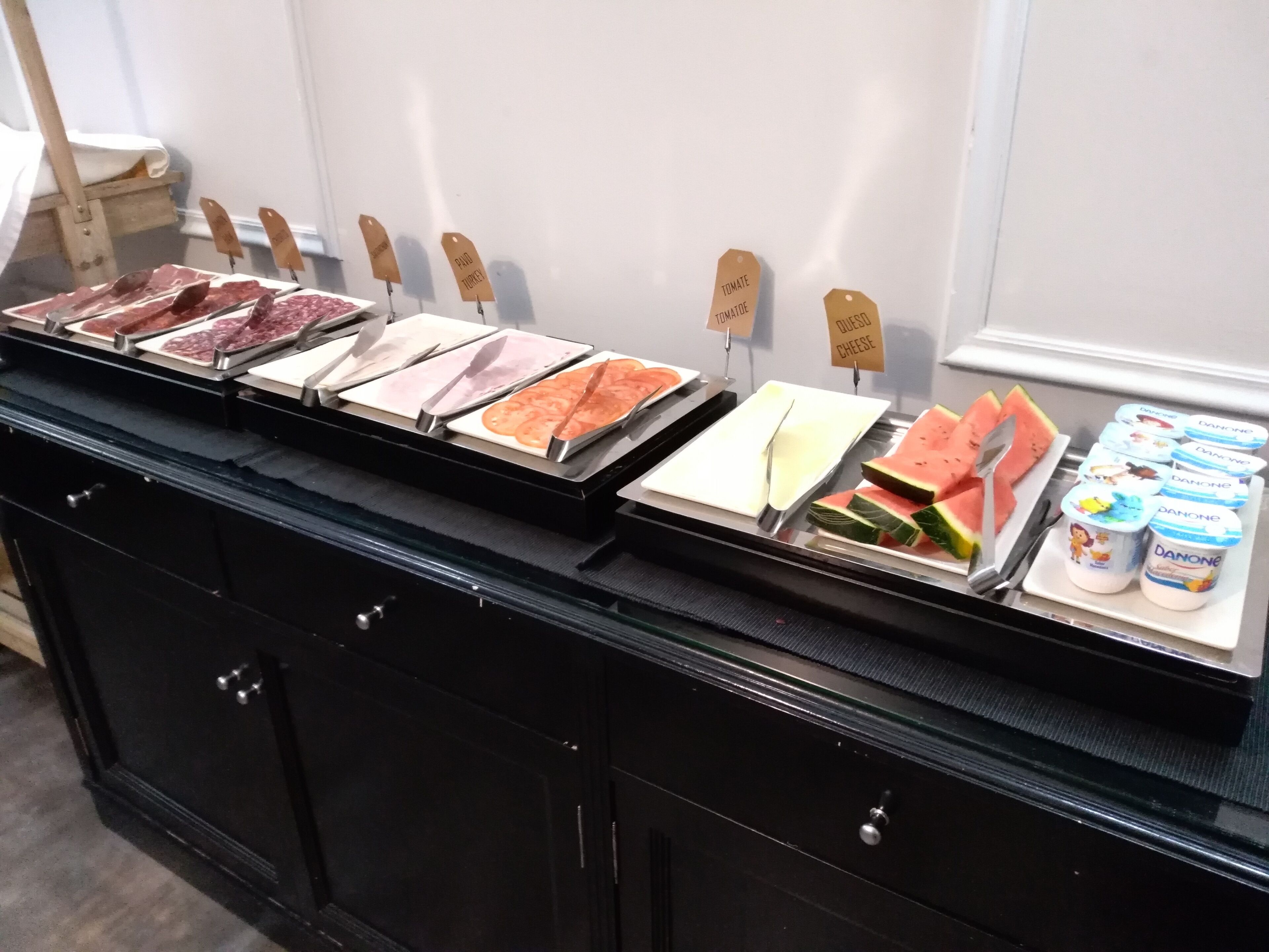 A food display with various meats, cheese, and watermelon slices.