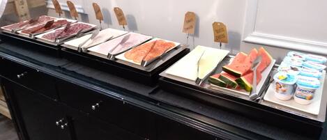 A food display with various meats, cheese, and watermelon slices.
