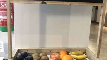 Un puesto de madera para frutas con un cartel de pizarra que dice