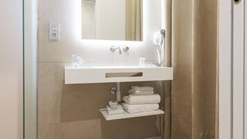 A bathroom with a white sink, mirror, and towel rack.