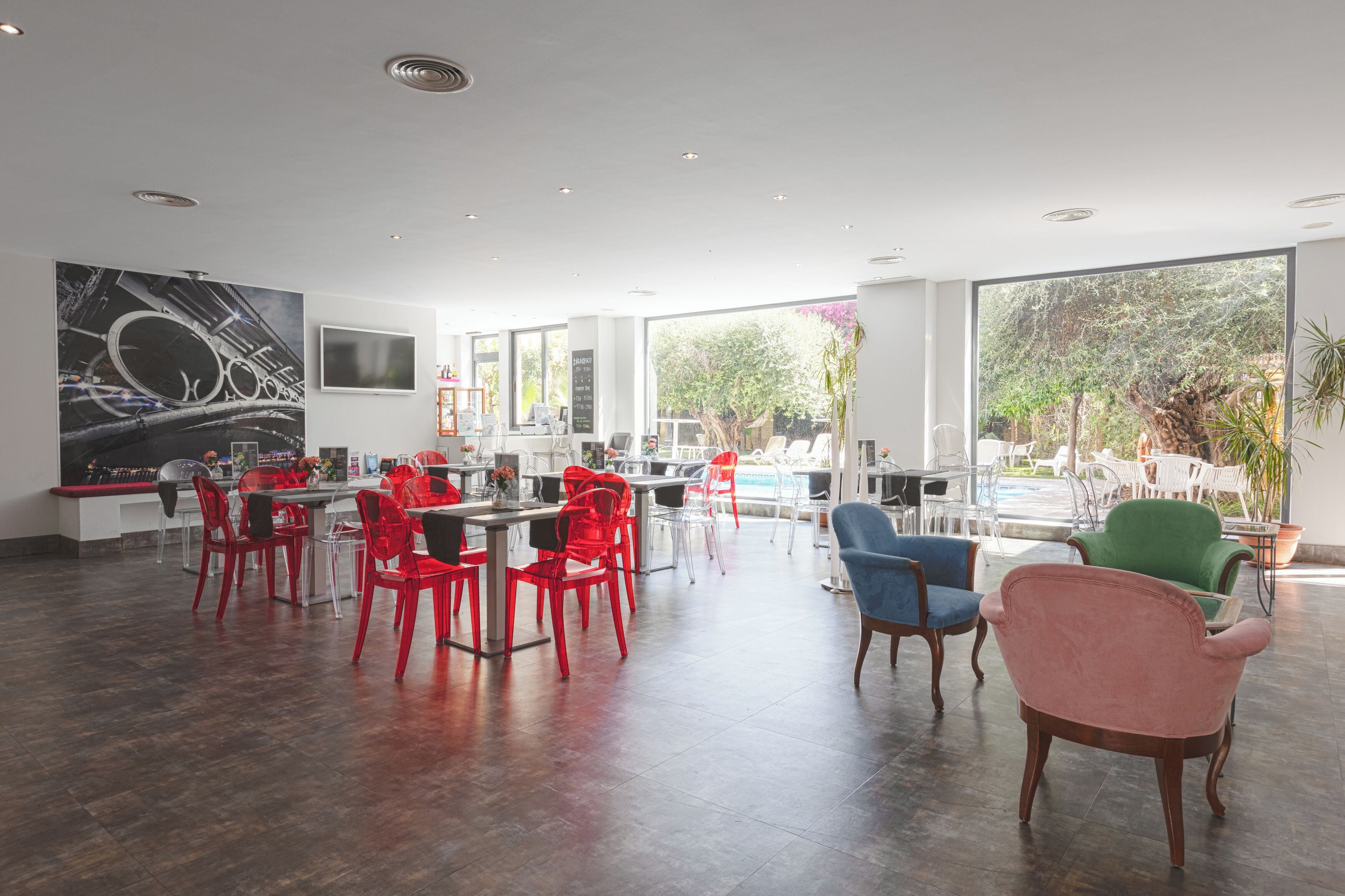 Un comedor amplio con sillas modernas, un ventanal grande y vistas al verdor exterior.