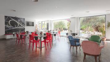 Un comedor amplio con sillas modernas, un ventanal grande y vistas al verdor exterior.