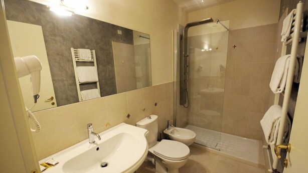 A modern bathroom with a sink, toilet, and shower. - Hotel Azzi (Florence)