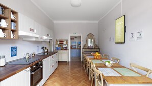 Eine Küche mit weißen Schränken, einer Holz Arbeitsplatte und einem Essbereich mit Tisch und Stühlen.