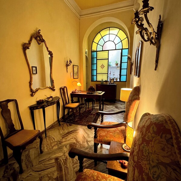 A room with a large arched window, a chandelier, and a patterned rug. - Hotel Cestelli (Florence)