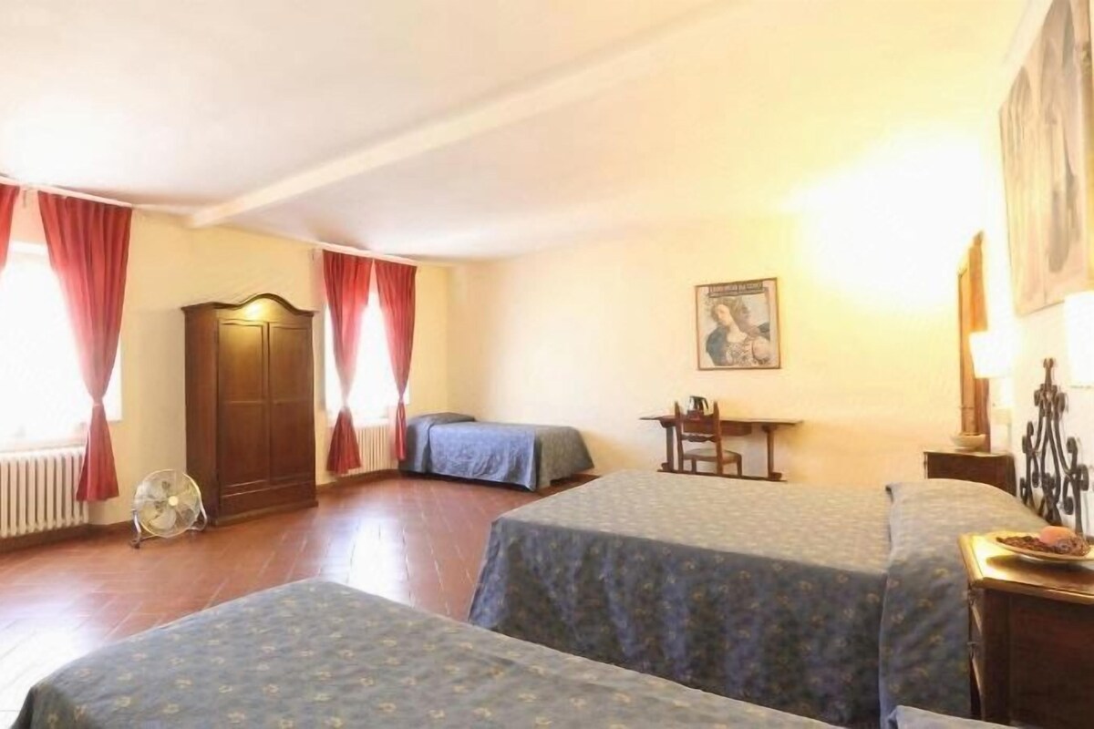 Une chambre d’hôtel avec deux lits, une armoire en bois, un bureau et une chaise.