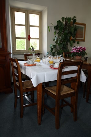 A dining table set with plates, glasses, and a vase of flowers. - Calzaiolo (San Casciano in Val di Pesa)