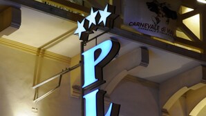 Un edificio con un cartello illuminato ben visibile con la scritta PLAYA.