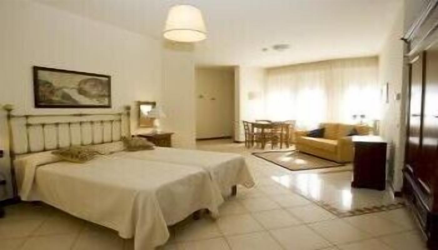 Una habitación de hotel con una cama, un escritorio, una silla y un sofá.