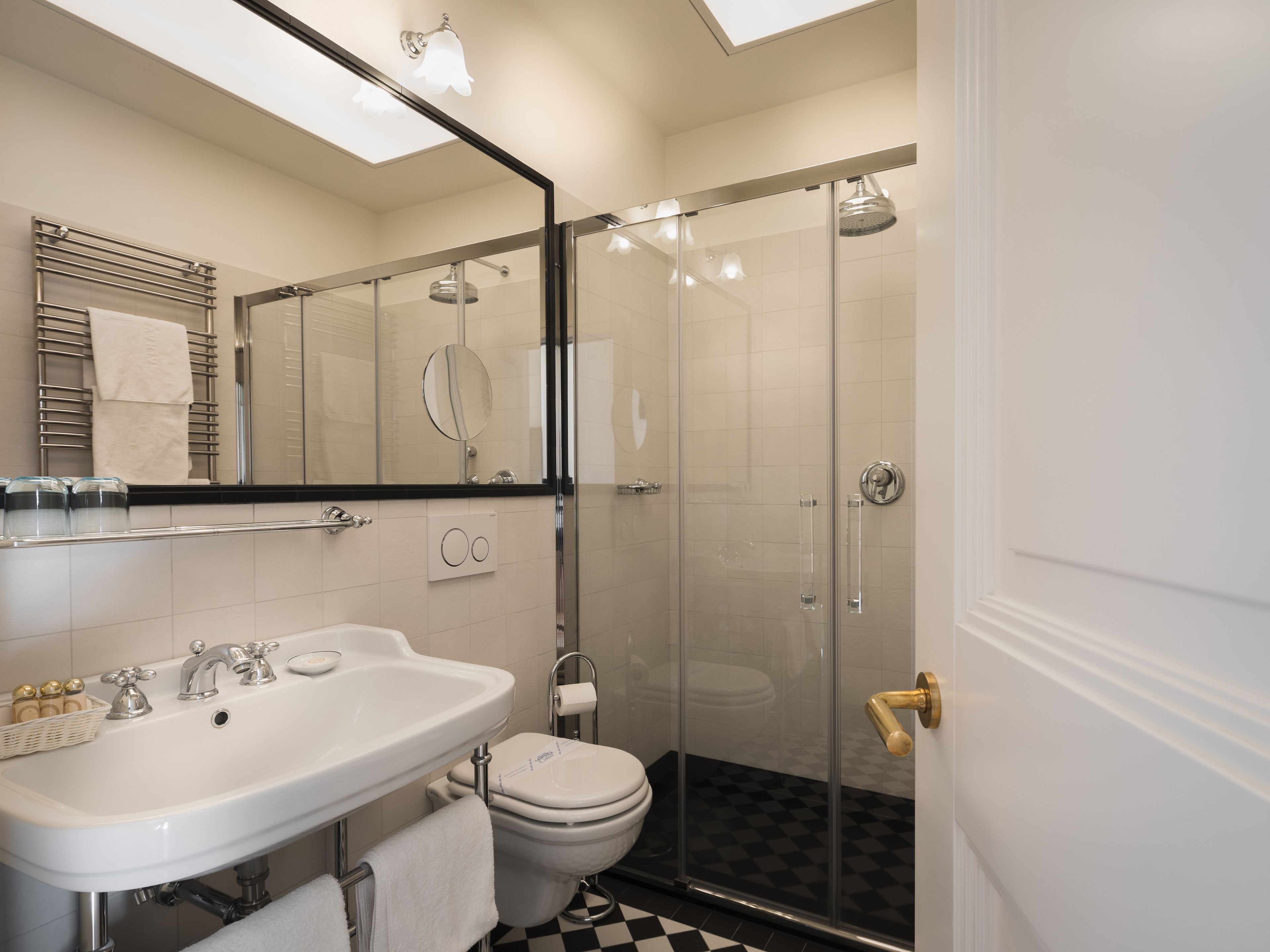A modern bathroom with a glass-enclosed shower, a white sink, and a toilet.