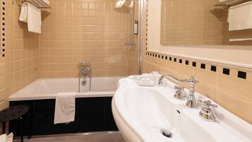 A bathroom with a bathtub, a shower, and a sink.