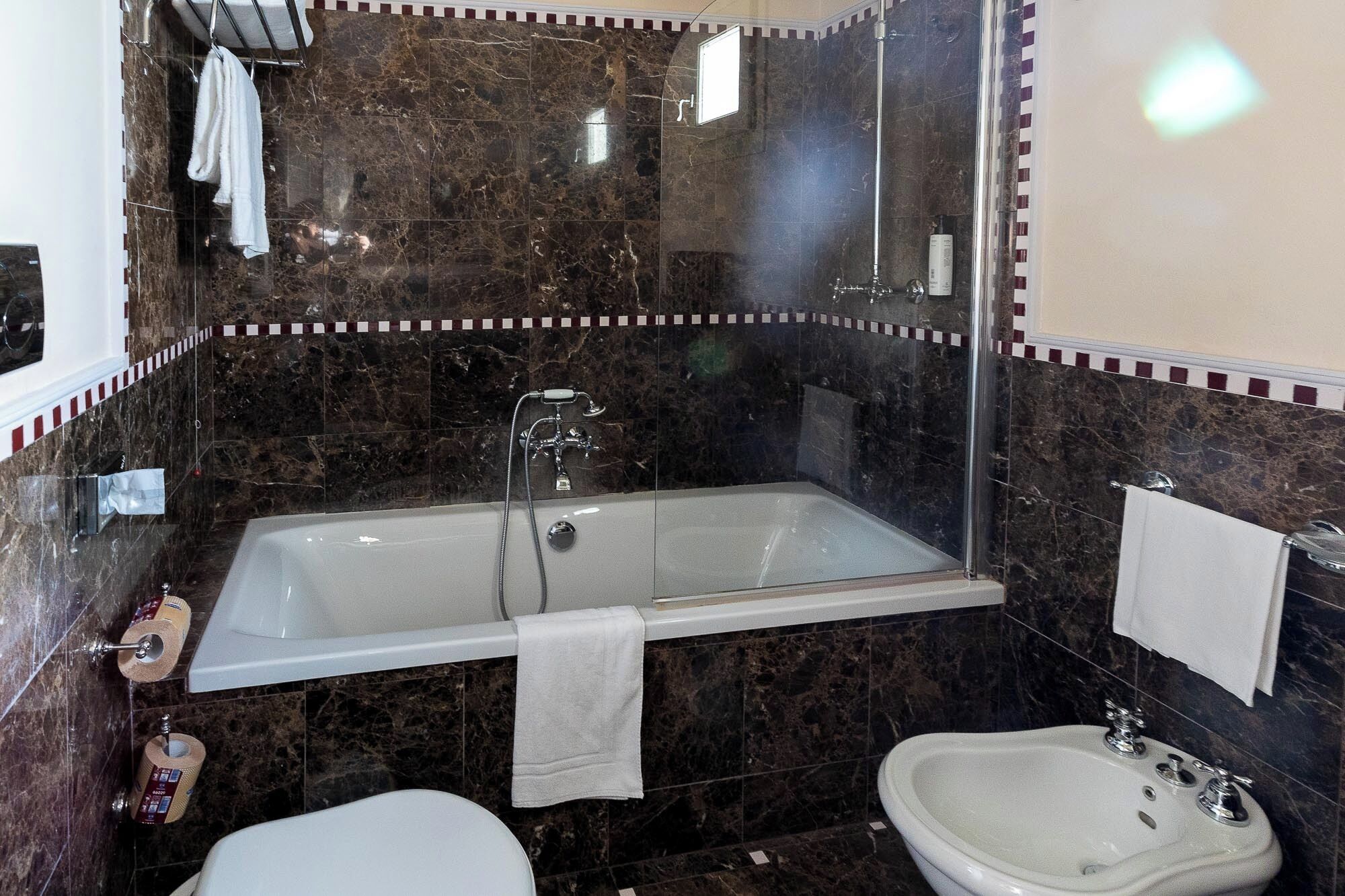 Un baño con bañera, lavamanos e inodoro.