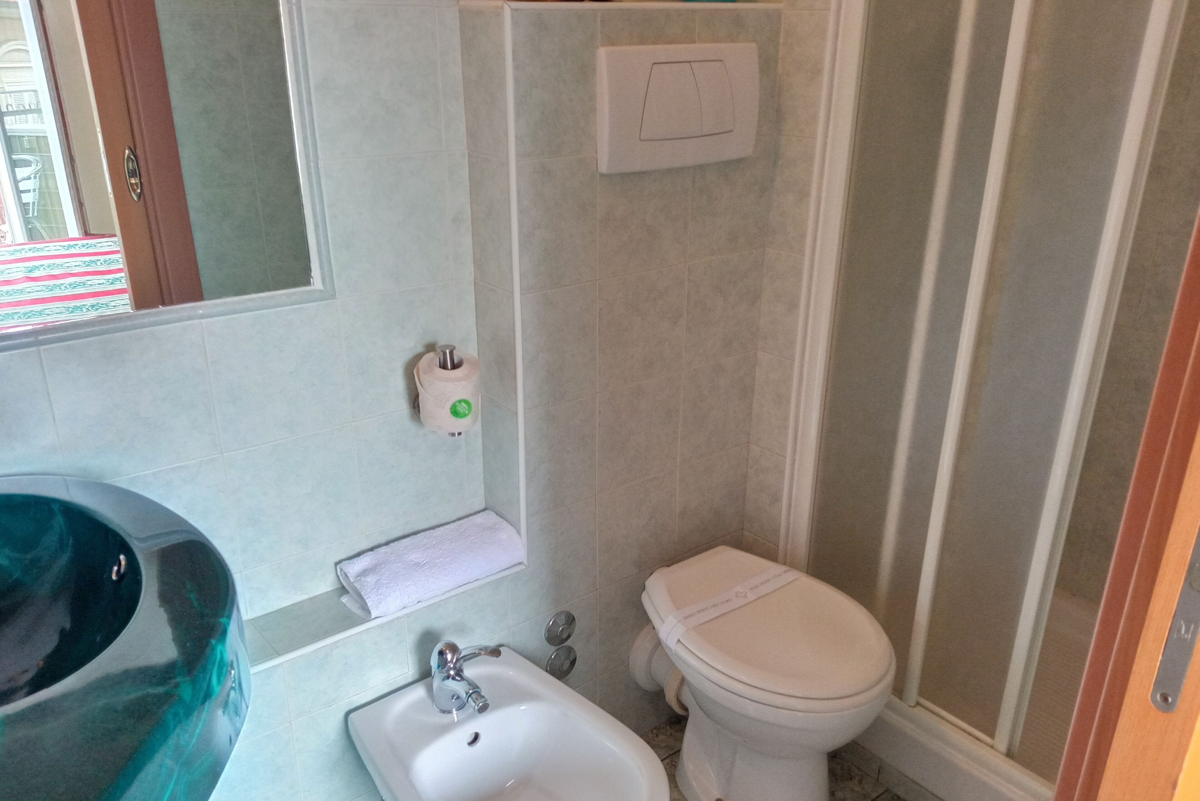 Une salle de bain avec un grand lavabo, des toilettes et un espace douche.