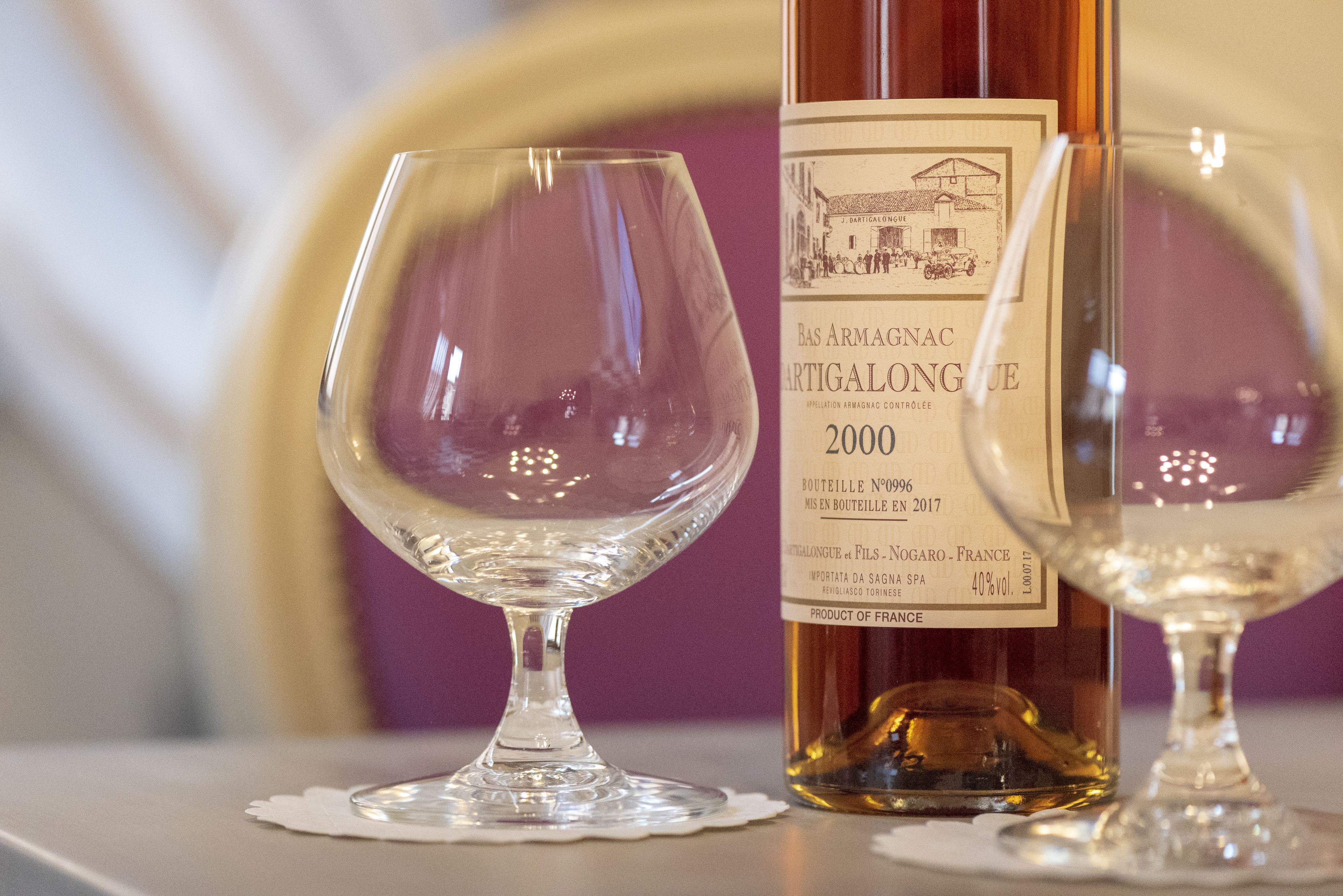 Two wine glasses and a bottle of Bas Armagnac 2000 on a table.