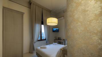 Une chambre d’hôtel avec un lit, une télévision et une table de chevet.