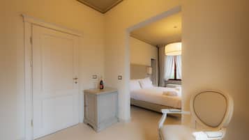 Una habitación de hotel con una cama, una silla, una mesita de noche y una puerta.