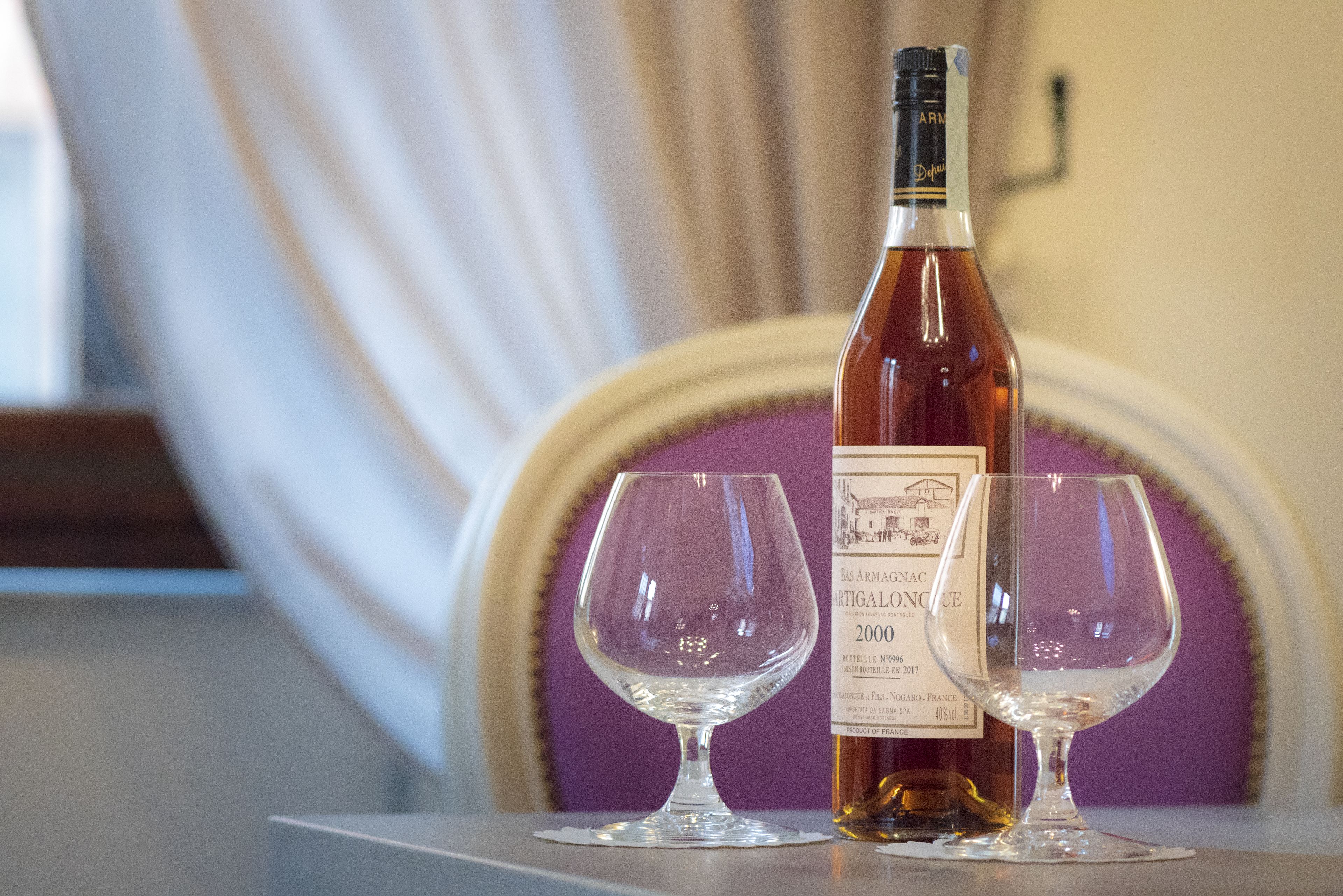 A bottle of wine and two glasses on a table.