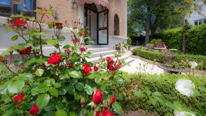 Een gebouw met een roze luifel en een tuin met rode en witte bloemen.